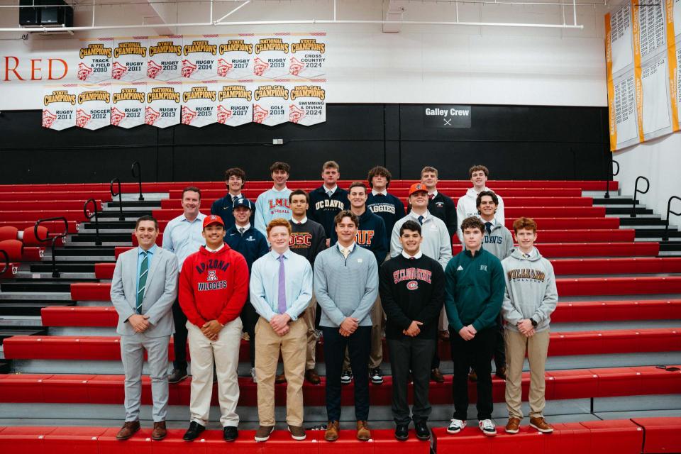 Group of seniors in college sweatshirts lined up in gym bleachers with administration
