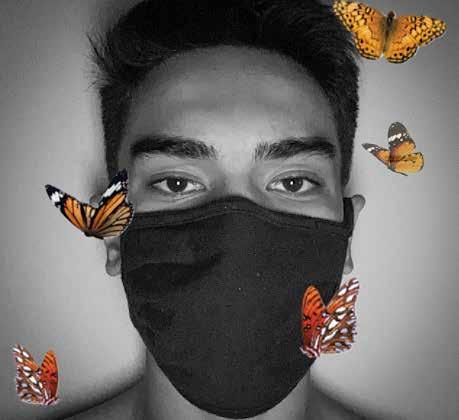 Black and white head shot of young man with COVID face mask surrounded by brightly colored butterflies.