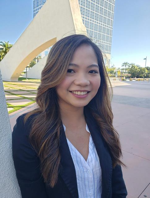 Photo of Aly smiling outside in professional attire