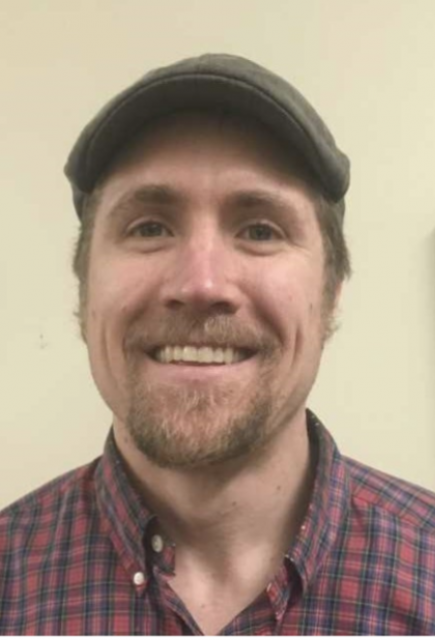 image of man smiling at camera in a collared shirt and cap