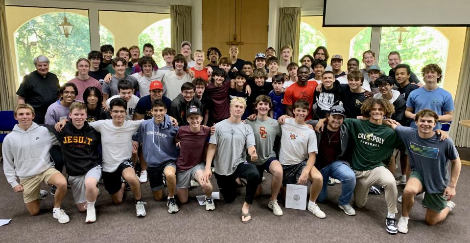 big group of students on retreat posing in front of windows 