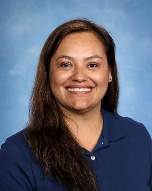 Studio head shot of Estela smiling